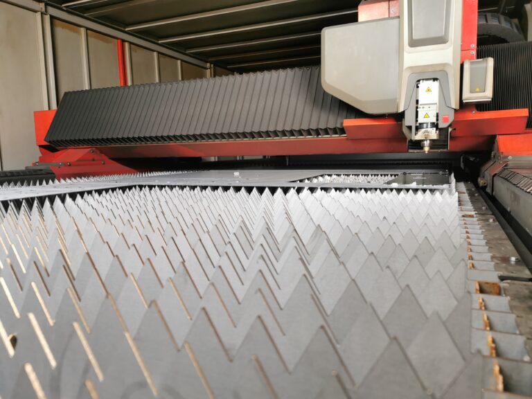 Interior view of the laser cutting machine at Midtherm Laser, showcasing the precise optics and cutting head.